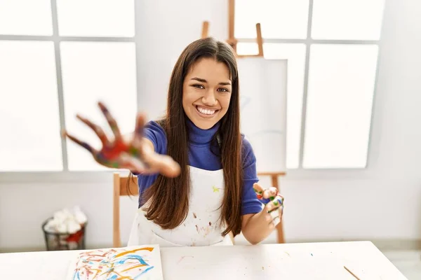 Młoda Latynoska Uśmiecha Się Pewnie Pokazując Malowane Dłonie Pracowni Artystycznej — Zdjęcie stockowe