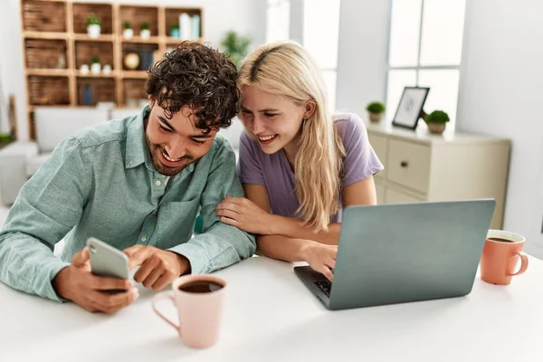 Unga Par Använder Laptop Och Smartphone Dricka Kaffe Hemma — Stockfoto