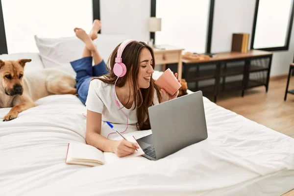 Young Hispanic Woman Studying Lying Bed Dogs Bedroom — ストック写真