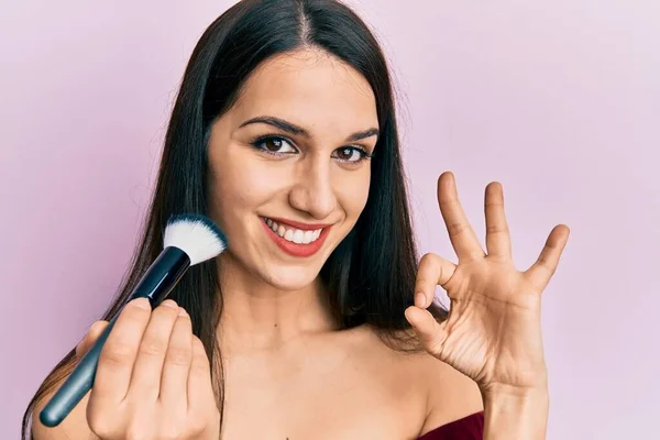 Young Hispanic Woman Holding Makeup Brush Blush Doing Sign Fingers — Stockfoto