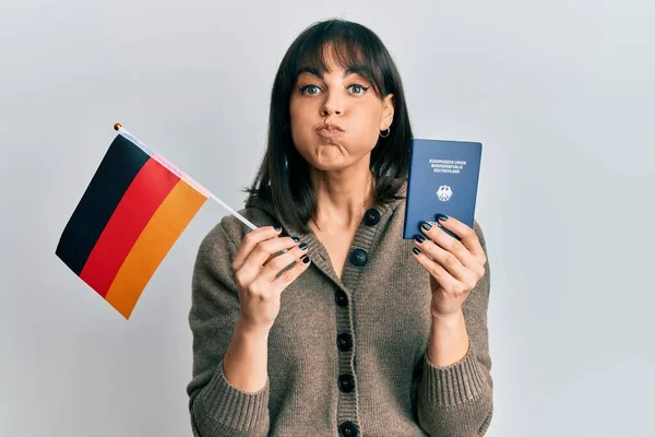 Ung Latinamerikansk Kvinna Håller Tyska Flagga Och Pass Puffande Kinder — Stockfoto