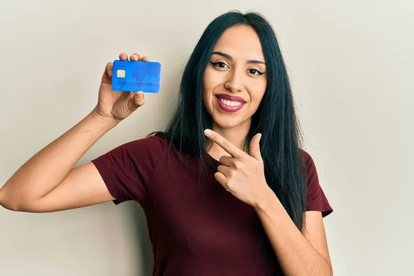 Young Hispanic Girl Holding Credit Card Smiling Happy Pointing Hand — 스톡 사진
