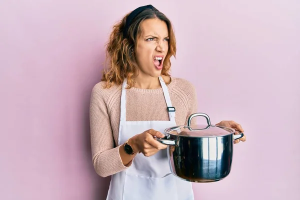 Young Caucasian Woman Wearing Apron Holding Cooking Pot Angry Mad — ストック写真