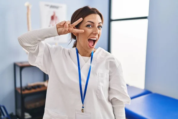 Young Brunette Woman Working Pain Recovery Clinic Doing Peace Symbol — Stock Photo, Image