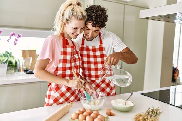 Casal Jovem Sorrindo Feliz Derramando Água Para Fazer Massa Para — Fotografia de Stock