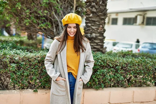 Genç İspanyol kız gülümseyerek şehirde mutlu mesut dikiliyor..