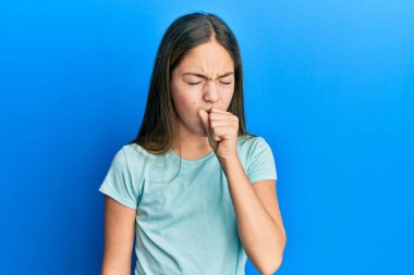 Güzel esmer, beyaz tişört giyen, kendini kötü hisseden ve soğuk algınlığı veya bronşitin belirtisi olarak öksüren küçük bir kız. sağlık hizmeti kavramı. 