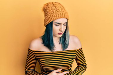 Genç, modern bir kız, midesi üstünde yün şapka takıyor. Çünkü hazımsızlık, acı verici bir hastalık ve kendini iyi hissetmiyor. Ağrı kavramı. 