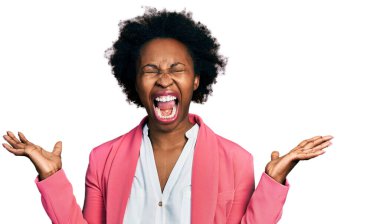 Afro saçlı, iş ceketi giyen Afrikalı Amerikalı bir kadın başarının çılgınlığını kollarını kaldırarak ve gözlerini kapatarak kutluyor. Heyecanlı çığlık atıyor. Kazanan konsept 