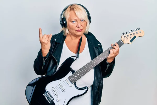 Mujer Rubia Mediana Edad Tocando Guitarra Eléctrica Haciendo Cuernos Signo — Foto de Stock