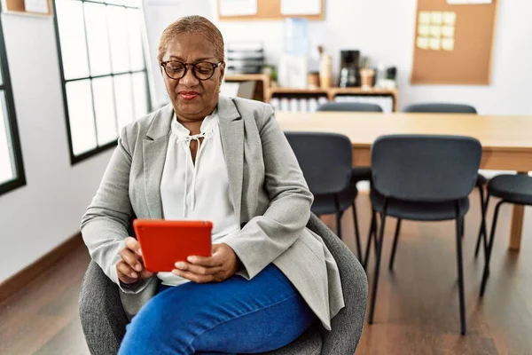 オフィスでタッチパッドを使用してシニアアフリカ系アメリカ人女性ビジネスワーカー — ストック写真