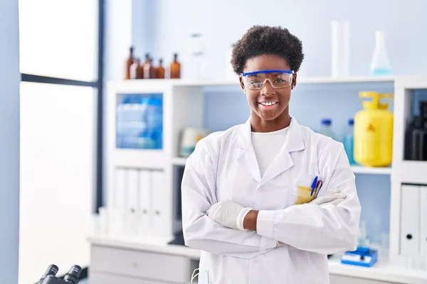 アフリカ系アメリカ人女性研究室で腕を組んで立っている科学者の制服を着て — ストック写真