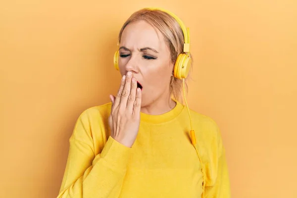 Mujer Rubia Joven Escuchando Música Usando Auriculares Aburridos Bostezando Cansada —  Fotos de Stock