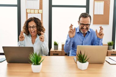 İki orta yaşlı iş adamı mutlu bir şekilde gülümsüyor ve ofiste şans diliyor..