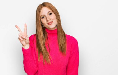 Genç İrlandalı kadın gündelik giysiler giyer ve iki numarayı göstererek gülümserken kendinden emin ve mutluydu.. 