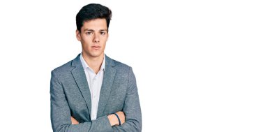 Kollarını kavuşturmuş genç İspanyol iş adamı yüzünde ciddi bir ifadeyle rahatlamış. Basit ve doğal bir şekilde kameraya bakıyorsun.. 