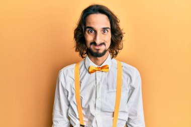 Hipster şık giyinen genç İspanyol adam komik yüzlü yanakları şişiriyor. Havayla şişmiş ağız, çılgın bir ifade.. 