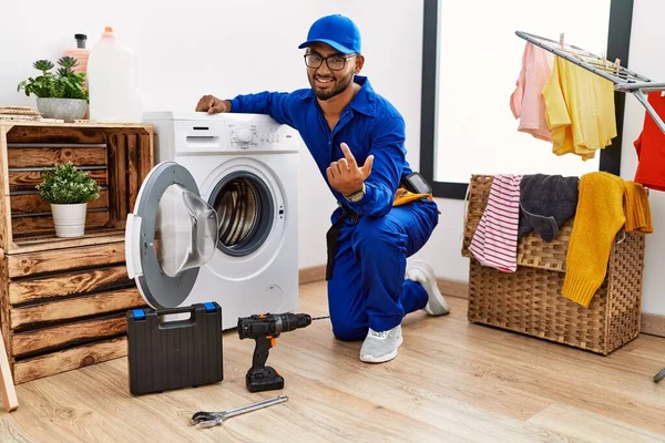 洗濯機の手招きに取り組む若いインドの技術者は 幸せと笑顔を歓迎する手でここにジェスチャーを来る — ストック写真