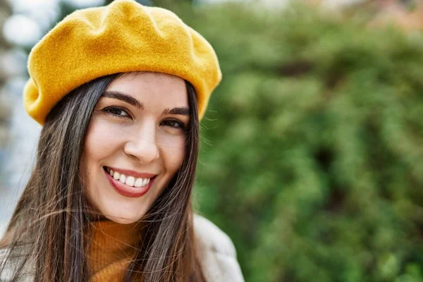 Genç İspanyol kız gülümseyerek şehirde mutlu mesut dikiliyor..