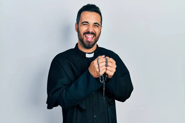 Όμορφος Ισπανός Ιερέας Γενειάδα Προσεύχεται Κρατώντας Καθολικό Κομπολόι Βγάζοντας Γλώσσα — Φωτογραφία Αρχείου