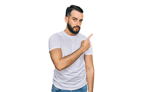 Junger Mann Mit Bart Trägt Legeres Weißes Shirt Zeigt Mit — Stockfoto