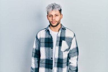 Modern boyalı saçlı, rahat gömlekli, yüzünde ciddi bir ifade olan genç bir İspanyol. Basit ve doğal bir şekilde kameraya bakıyorsun.. 