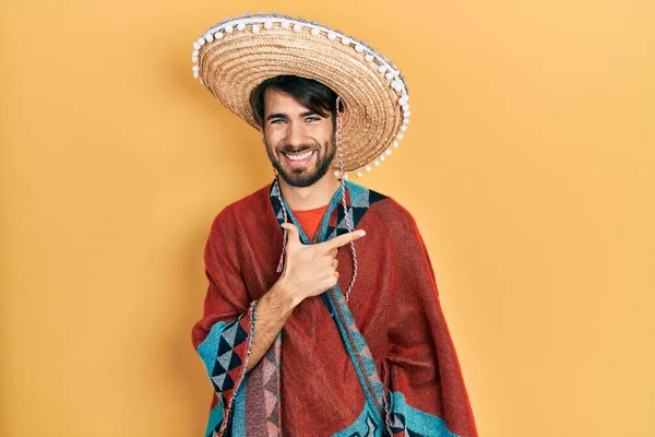 Jovem Hispânico Segurando Chapéu Mexicano Alegre Com Sorriso Rosto Apontando — Fotografia de Stock