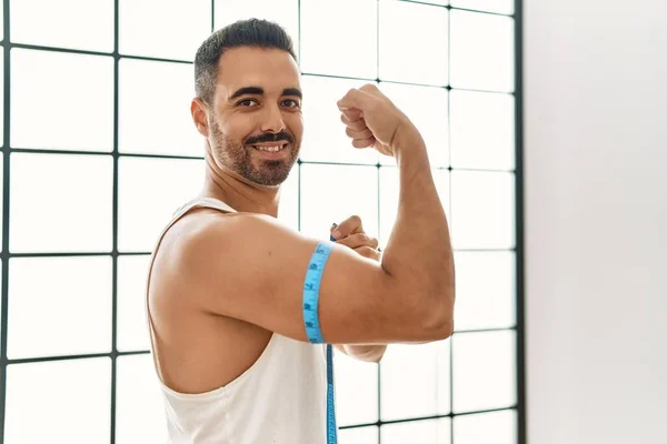 Joven Hombre Hispano Sonriendo Confiado Midiendo Músculo Del Brazo Con —  Fotos de Stock