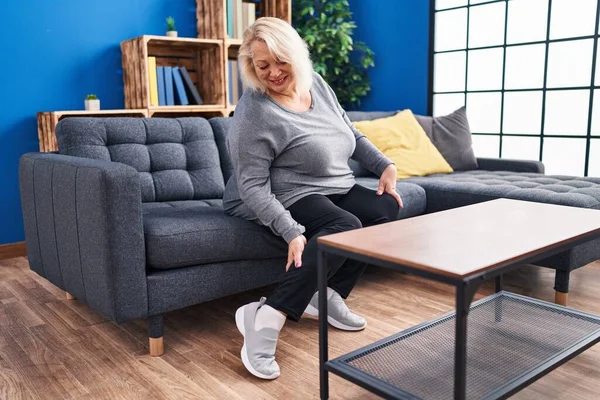 Middle Age Blonde Woman Wearing Sneaker Sitting Sofa Home — Fotografia de Stock