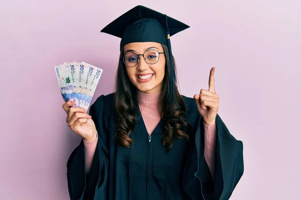 Young Hispanic Woman Wearing Graduation Uniform Holding Colombia Pesos Banknotes — Stock Photo, Image