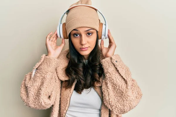 Mujer Hispana Joven Escuchando Música Usando Auriculares Escépticos Nerviosos Frunciendo — Foto de Stock