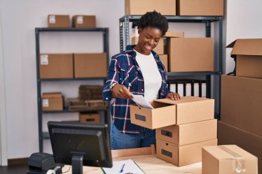 Afrikalı Amerikalı kadın ecommerce işçisi ofisteki çekmeceye belge koydu.