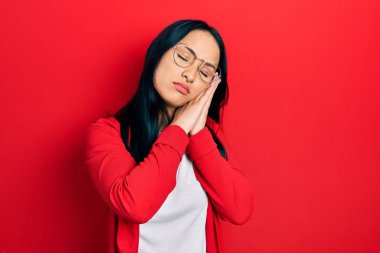 Güzel İspanyol bir kadın, burun piercingli, sıradan bakışlı, gözlüklü, uykulu, yorgun, hayal kuran, elleriyle poz veren, kapalı gözlerle gülümseyen.. 