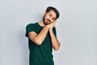 Latin kökenli genç bir adam, günlük beyaz tişört giyer, uyur, yorgun düşler görür, elleriyle poz verir ve gözleri kapalı gülümserdi.. 