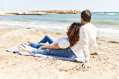 Orta yaşlı İspanyol çift plajda havluda otururken rahatladı..