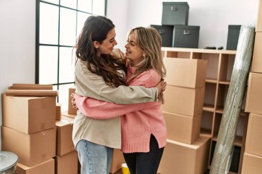 Genç çift mutlu bir şekilde gülümsüyor ve yeni evlerinde sarılıyorlar..