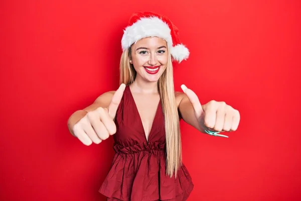 Joven Chica Rubia Con Sombrero Navidad Aprobando Hacer Gesto Positivo — Foto de Stock