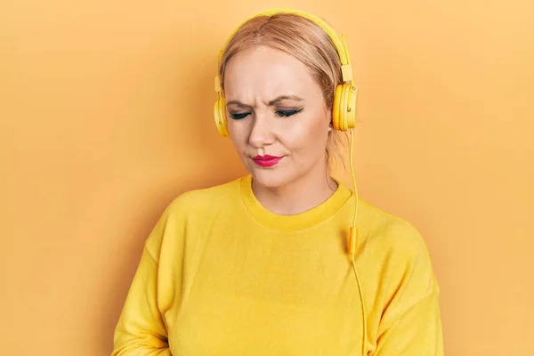 Mujer Rubia Joven Escuchando Música Usando Auriculares Con Mano Estómago —  Fotos de Stock