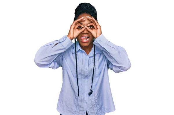 若いアフリカ系アメリカ人の女性は 双眼鏡で舌を出し 目は指を通して見るなど カジュアルな服装をしています クレイジーな表現 — ストック写真