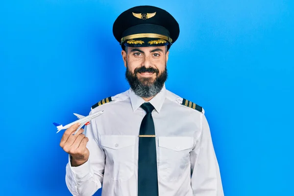 Mladý Hispánec Muž Nosí Pilotní Uniformu Drží Letadlo Hračka Vypadá — Stock fotografie