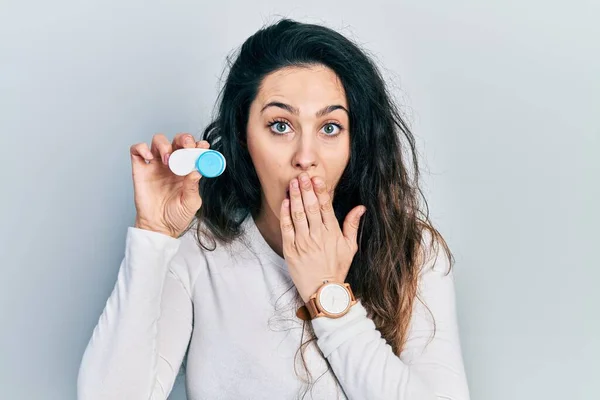 Young Hispanic Woman Holding Contact Lenses Covering Mouth Hand Shocked — Stock Photo, Image