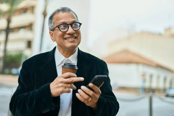 동남아시아의 남자가 스마트폰으로 웃으며 도시에서 커피를 마시고 있습니다 — 스톡 사진