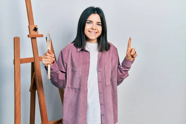 Genç Esmer Kadın Ressam Sanat Stüdyosunda Oturmuş Elinde Sanat Sözcüğü — Stok fotoğraf