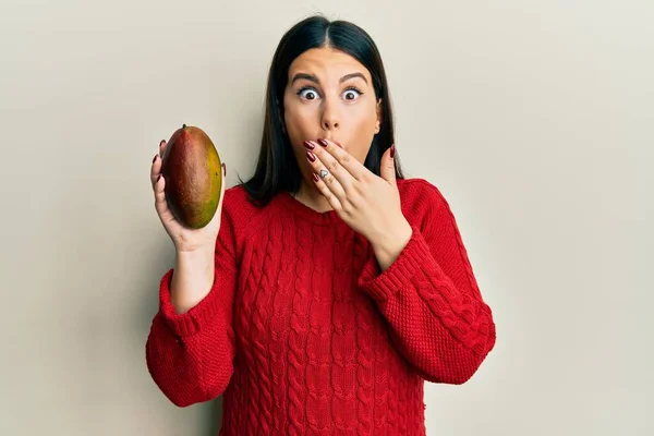 Vacker Brunett Kvinna Håller Mango Täcker Munnen Med Handen Chockad — Stockfoto