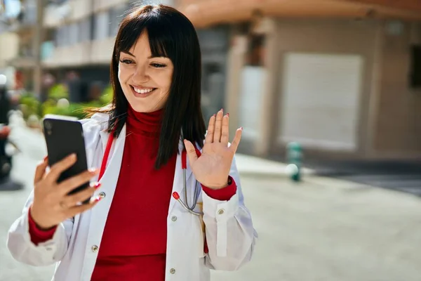 年轻的黑发女人穿着医生制服 在城里用智能手机进行视频拍摄 — 图库照片