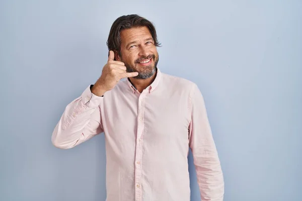 携帯電話で話すような手や指で携帯電話のジェスチャーを行う笑顔エレガントなシャツの背景を着てハンサムな中年の男性 コミュニケーションの概念 — ストック写真