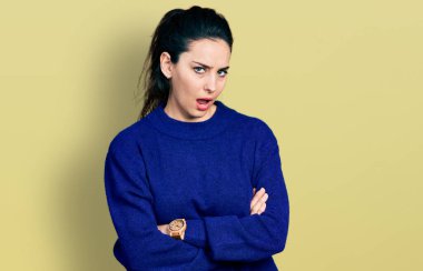 Kolları çapraz hareket eden genç İspanyol kadın şok olmuş, şüpheci ve alaycı görünüyor, ağzı açık kalınca şaşırıyor. 