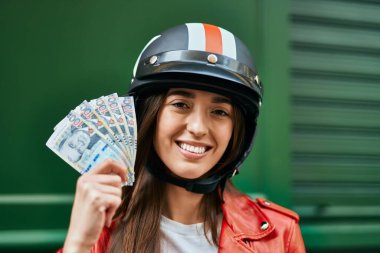 Moto başlık takan ve şehirde Peru sol banknotları tutan genç İspanyol kadın..