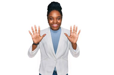 Genç Afro-Amerikan kadın iş kıyafetleri giyip on numarayı gösterip işaret ederken kendinden emin ve mutlu bir şekilde gülümsüyor.. 