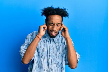 Gürültülü müzik sesi için sakallı, kulakları parmaklarıyla kulaklarını kapatan Afro-Amerikalı genç bir adam. sağır kavramı. 